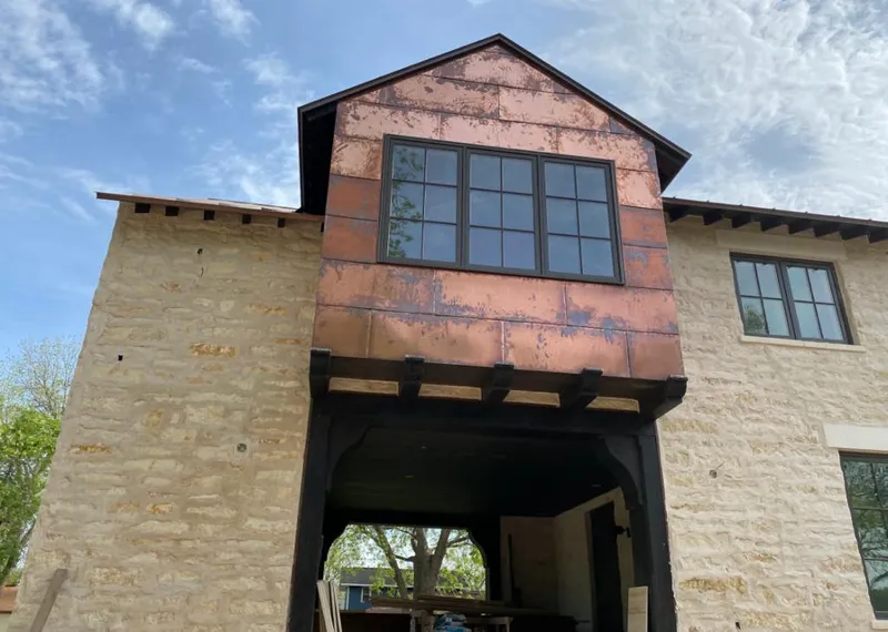 Copper metal panel facade on a stone building for Roof Repair in Cayce